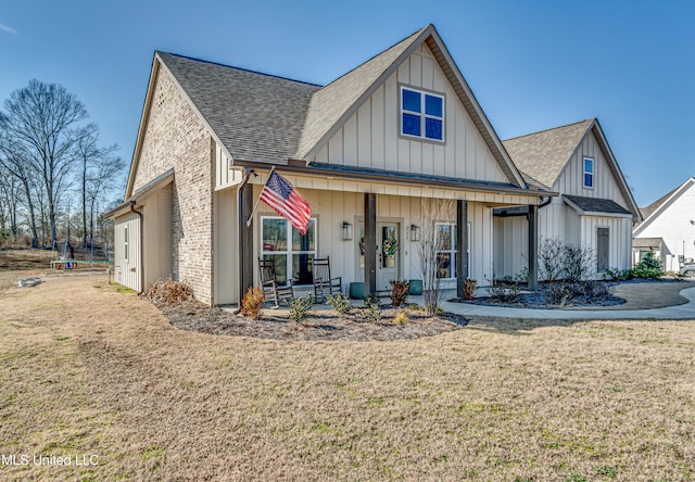 view of front facade featuring a front lawn and covered porch