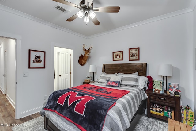 bedroom with crown molding, hardwood / wood-style floors, and ceiling fan