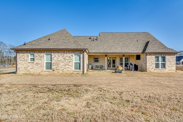 rear view of house with a lawn and a patio