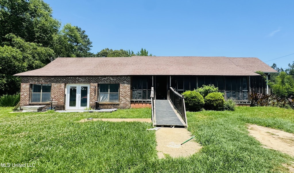 ranch-style home with a front lawn and a sunroom