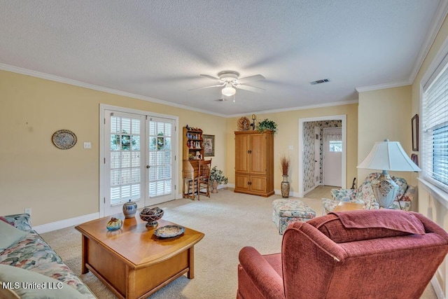 living room with a textured ceiling, french doors, ceiling fan, light colored carpet, and crown molding