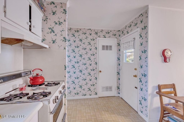 kitchen with crown molding, white cabinets, and white gas range oven