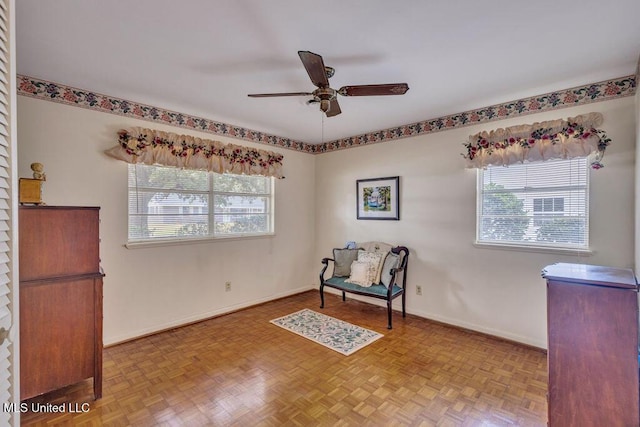 sitting room featuring ceiling fan and light parquet floors