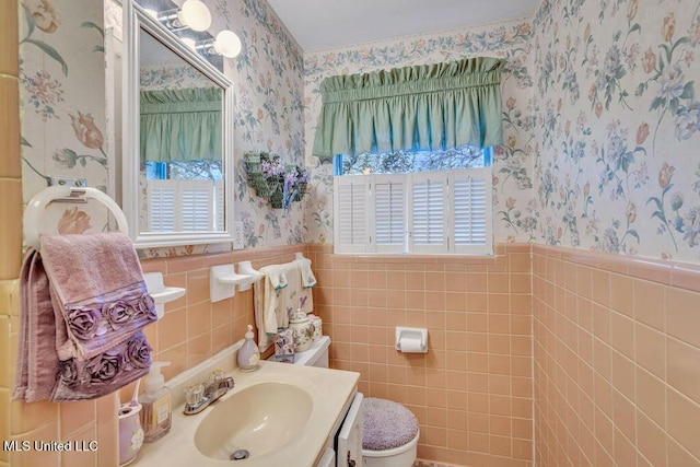 bathroom featuring tile walls, toilet, and vanity