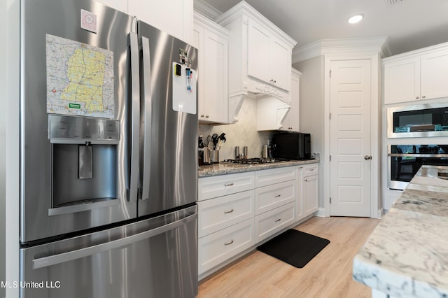 16872 W Landon Green Cir, Gulfport, MS 39503 - kitchen with stainless steel appliances, white cabinetry, light wood finished floors, recessed lighting, and light stone counters