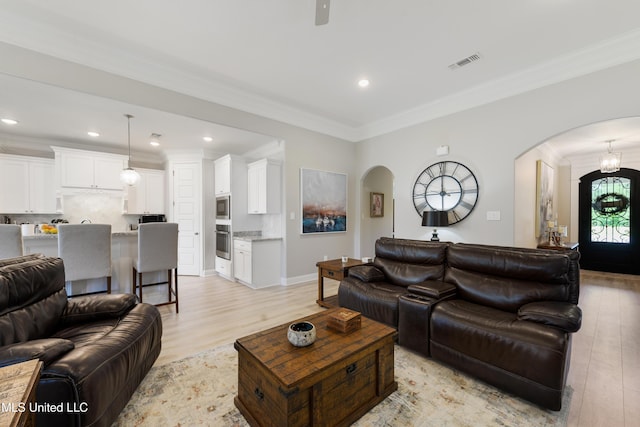 16872 W Landon Green Cir, Gulfport, MS 39503 - living room featuring arched walkways, light wood-style flooring, ornamental molding, recessed lighting, and baseboards