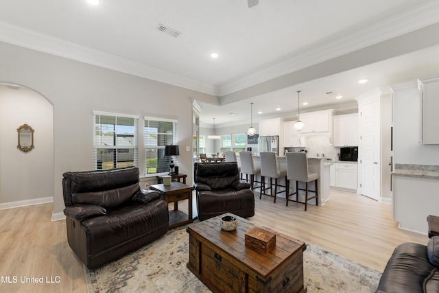 16872 W Landon Green Cir, Gulfport, MS 39503 - living room with light wood-style flooring, ornamental molding, recessed lighting, arched walkways, and baseboards