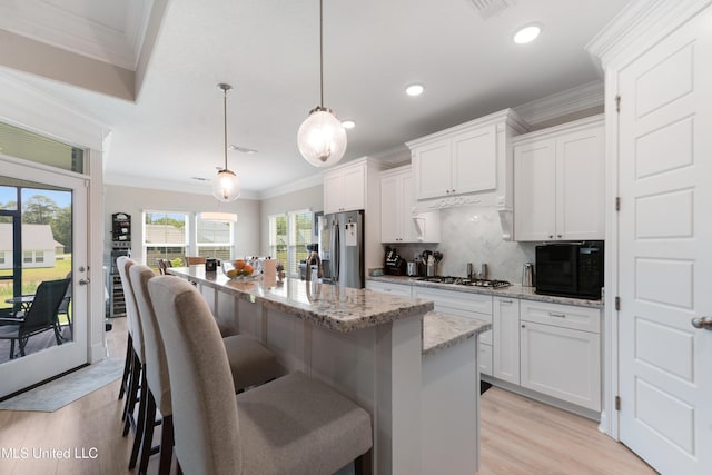 16872 W Landon Green Cir, Gulfport, MS 39503 - kitchen featuring stainless steel fridge with ice dispenser, light wood finished floors, ornamental molding, black microwave, and backsplash