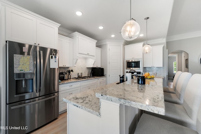 16872 W Landon Green Cir, Gulfport, MS 39503 - kitchen featuring appliances with stainless steel finishes, arched walkways, recessed lighting, a breakfast bar, and ornamental molding