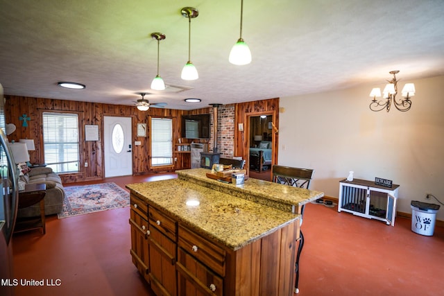 kitchen featuring open floor plan, concrete floors, a textured ceiling, and a wood stove