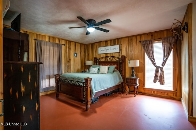 bedroom featuring wooden walls, multiple windows, and ceiling fan