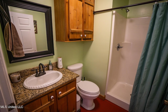 bathroom with a shower stall, toilet, and vanity