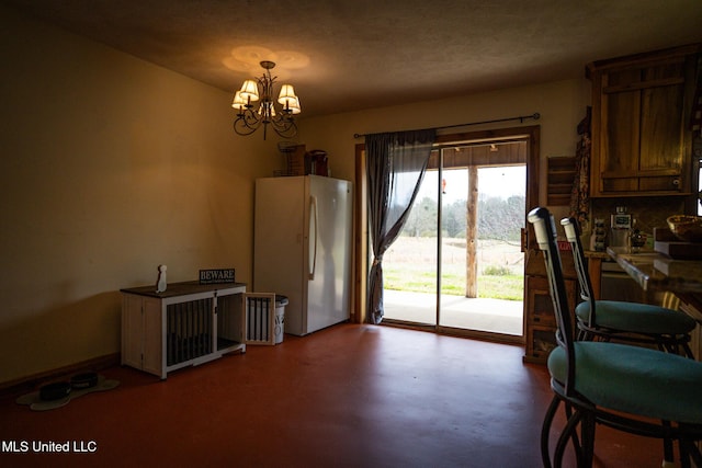 dining room with concrete floors and a chandelier