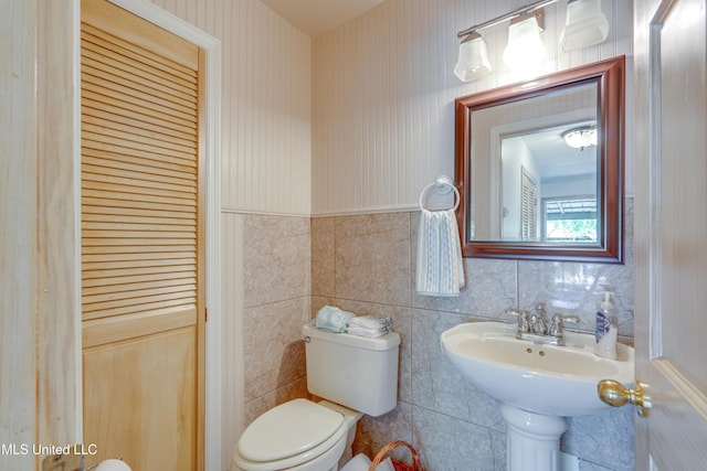6132 Shawnee St, Kiln, MS 39556 - half bathroom with wainscoting, tile walls, and wallpapered walls