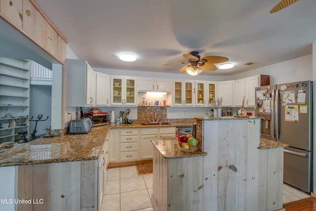 6132 Shawnee St, Kiln, MS 39556 - kitchen with stainless steel appliances, a ceiling fan, a kitchen island, stone counters, and glass insert cabinets