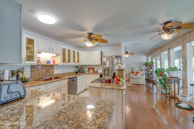 6132 Shawnee St, Kiln, MS 39556 - kitchen featuring stainless steel appliances, a ceiling fan, a kitchen island, light stone counters, and glass insert cabinets