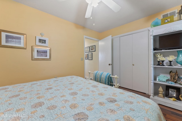 bedroom with a closet, ceiling fan, and dark hardwood / wood-style floors