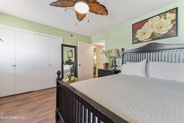 bedroom featuring a closet, ceiling fan, a textured ceiling, and dark hardwood / wood-style floors