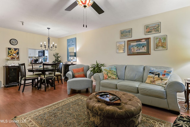 living room with dark wood-type flooring and ceiling fan with notable chandelier