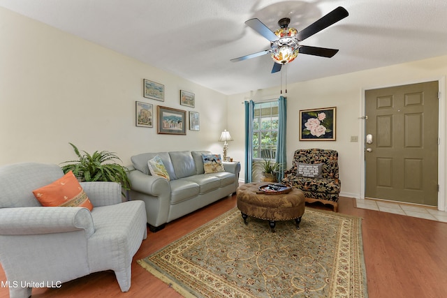 living room with ceiling fan, a textured ceiling, and light hardwood / wood-style flooring