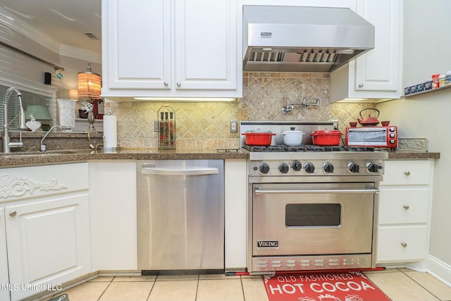 kitchen featuring white cabinetry, stainless steel appliances, tasteful backsplash, ventilation hood, and light tile patterned floors