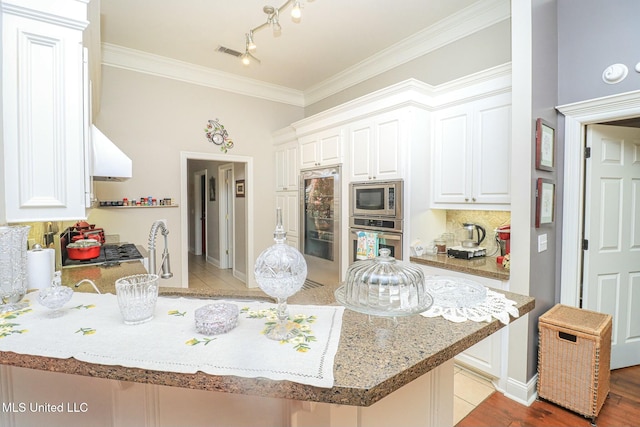 kitchen featuring kitchen peninsula, stainless steel appliances, white cabinetry, and light hardwood / wood-style flooring