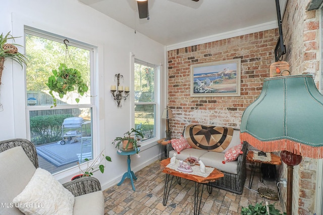 sitting room featuring ceiling fan and brick wall