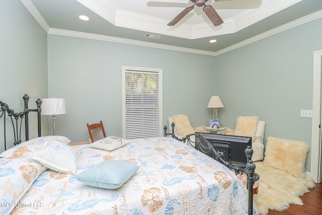 bedroom with a raised ceiling, ceiling fan, hardwood / wood-style flooring, and ornamental molding