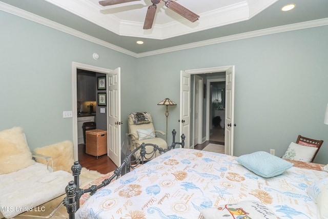 bedroom with hardwood / wood-style flooring, ceiling fan, a raised ceiling, and ornamental molding