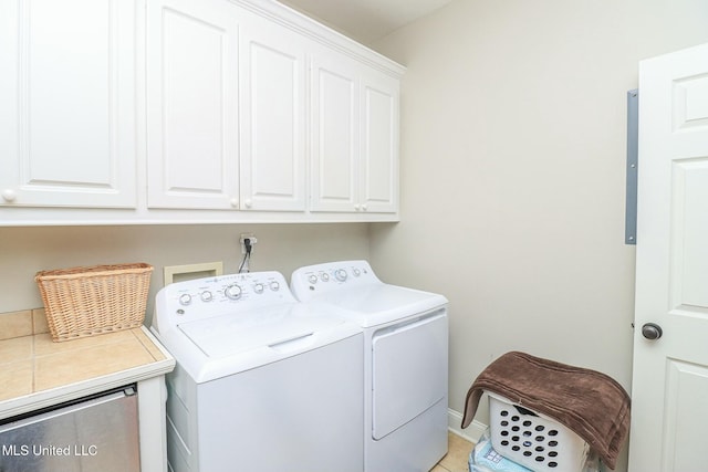 laundry room with separate washer and dryer, light tile patterned flooring, and cabinets