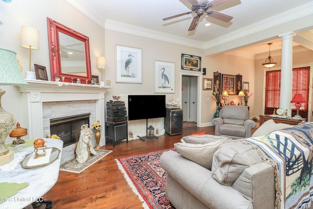 living room with dark hardwood / wood-style floors, a premium fireplace, crown molding, and decorative columns