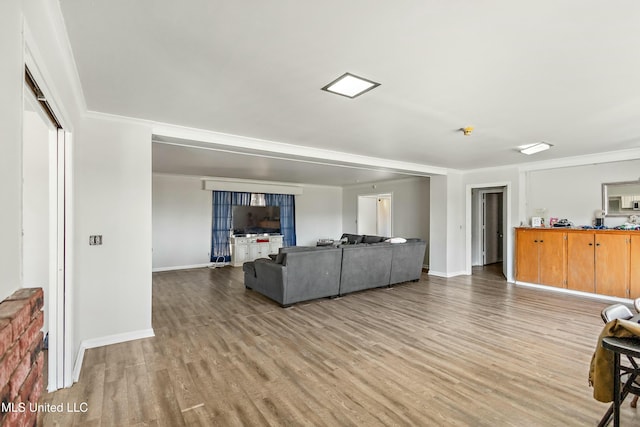 living room with crown molding and light wood-type flooring