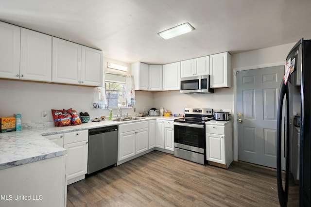 kitchen featuring dark wood-type flooring, appliances with stainless steel finishes, sink, and white cabinets