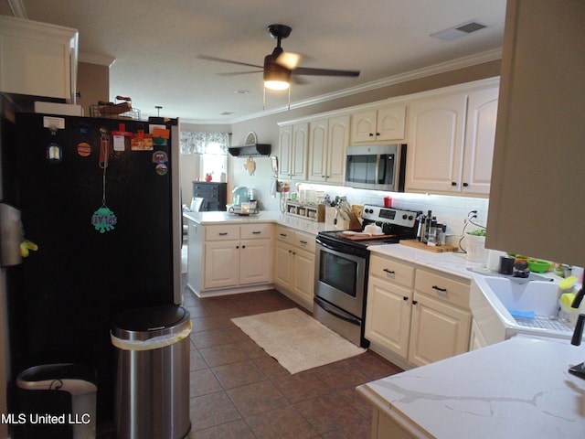 70 Tree Line Dr, Mount Pleasant, MS 38635 - kitchen with appliances with stainless steel finishes, crown molding, a peninsula, a ceiling fan, and dark tile patterned flooring