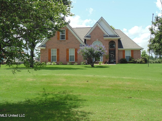 70 Tree Line Dr, Mount Pleasant, MS 38635 - traditional-style house featuring brick siding, a front yard, and a shingled roof