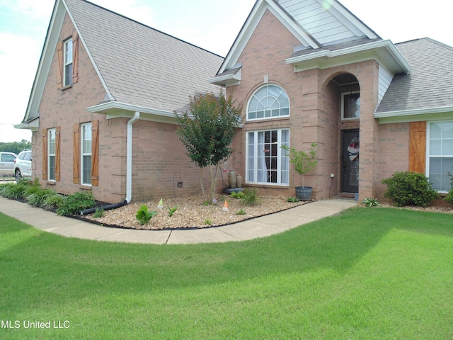 70 Tree Line Dr, Mount Pleasant, MS 38635 - view of property exterior featuring brick siding, roof with shingles, and a lawn
