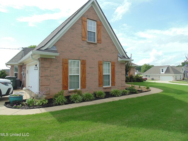 70 Tree Line Dr, Mount Pleasant, MS 38635 - view of side of home featuring an attached garage, a yard, brick siding, and a shingled roof
