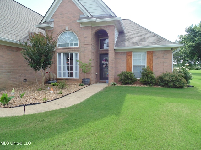 70 Tree Line Dr, Mount Pleasant, MS 38635 - view of front facade featuring brick siding, a front yard, and roof with shingles