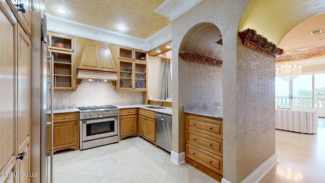 kitchen with sink, stainless steel appliances, an inviting chandelier, premium range hood, and backsplash