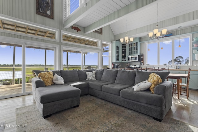 living area with hardwood / wood-style floors, a chandelier, high vaulted ceiling, and plenty of natural light