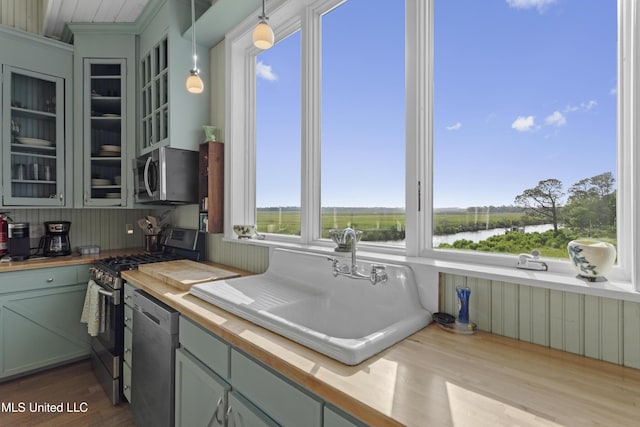 kitchen with wood counters, a sink, a healthy amount of sunlight, and appliances with stainless steel finishes