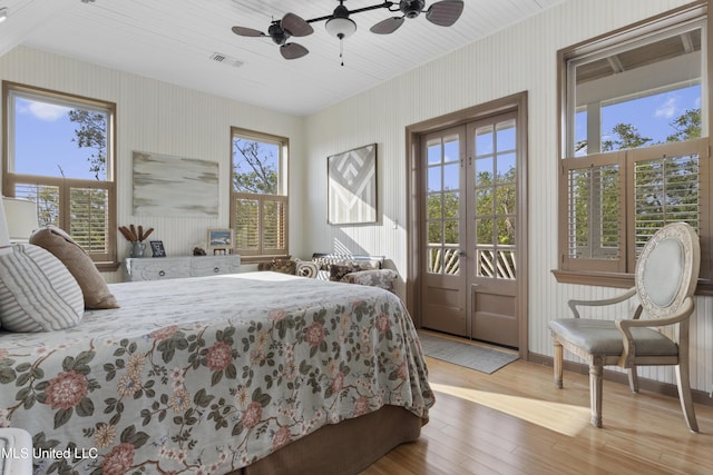 bedroom with hardwood / wood-style floors, visible vents, ceiling fan, access to outside, and wallpapered walls