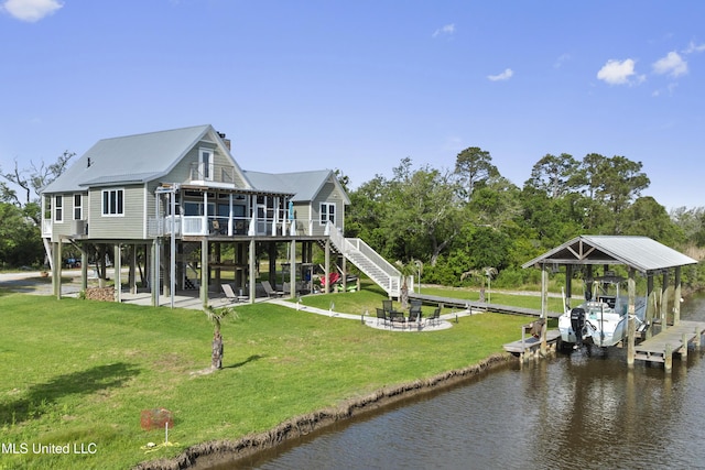 dock area featuring boat lift, stairway, a lawn, and a water view