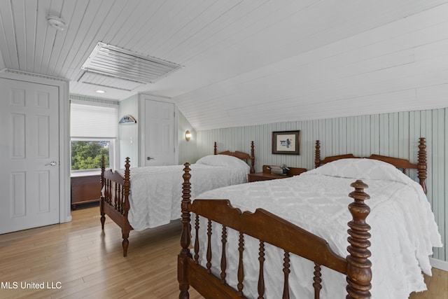 bedroom featuring light wood-style floors, vaulted ceiling, and wood ceiling