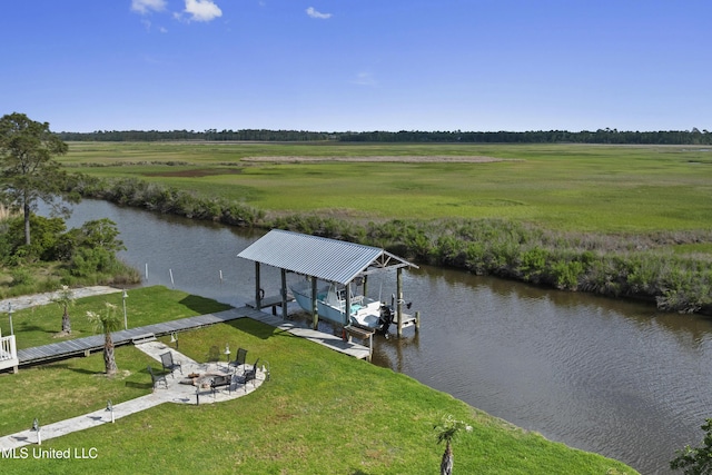 dock area featuring boat lift, a fire pit, a rural view, a lawn, and a water view
