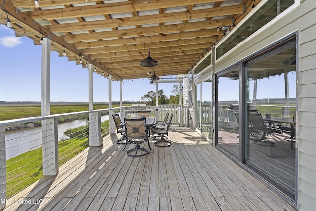 wooden deck featuring a water view and outdoor dining area