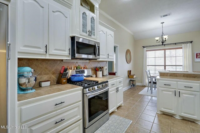 kitchen featuring light tile patterned floors, visible vents, stainless steel appliances, white cabinetry, and backsplash