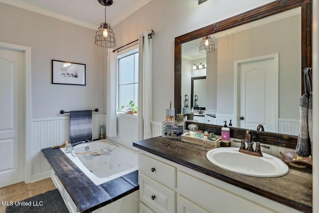 full bath with wainscoting, a tub with jets, tile patterned floors, crown molding, and vanity