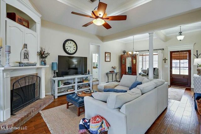 living area with ornamental molding, a brick fireplace, and dark wood finished floors