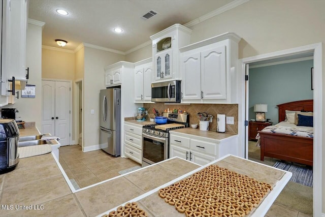 kitchen featuring light countertops, visible vents, decorative backsplash, appliances with stainless steel finishes, and white cabinetry